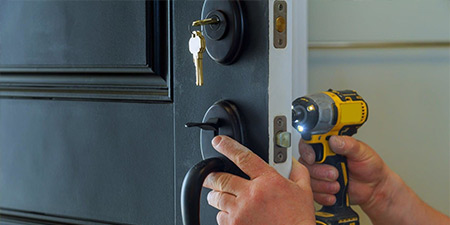 Locksmith unscrewing lock with tool