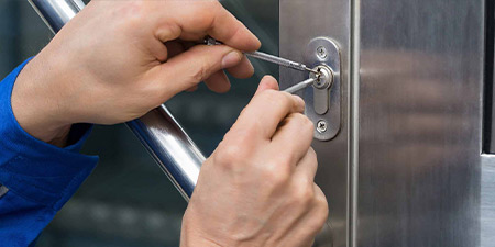 Locksmith opening commercial door with tools