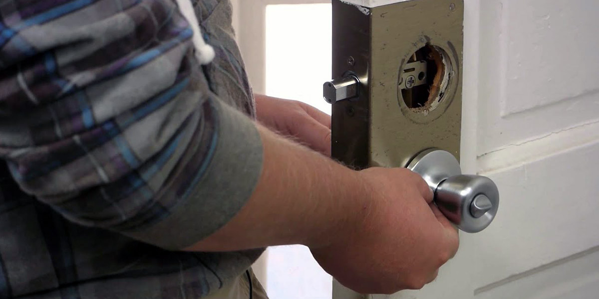A man replacing a door lock