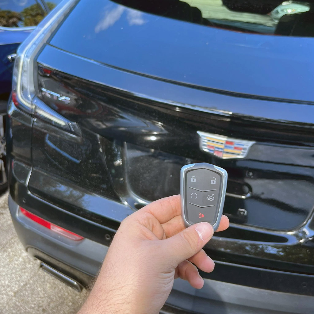 Cadillac key fob held in front of a black Cadillac SUV in Panama City Beach
