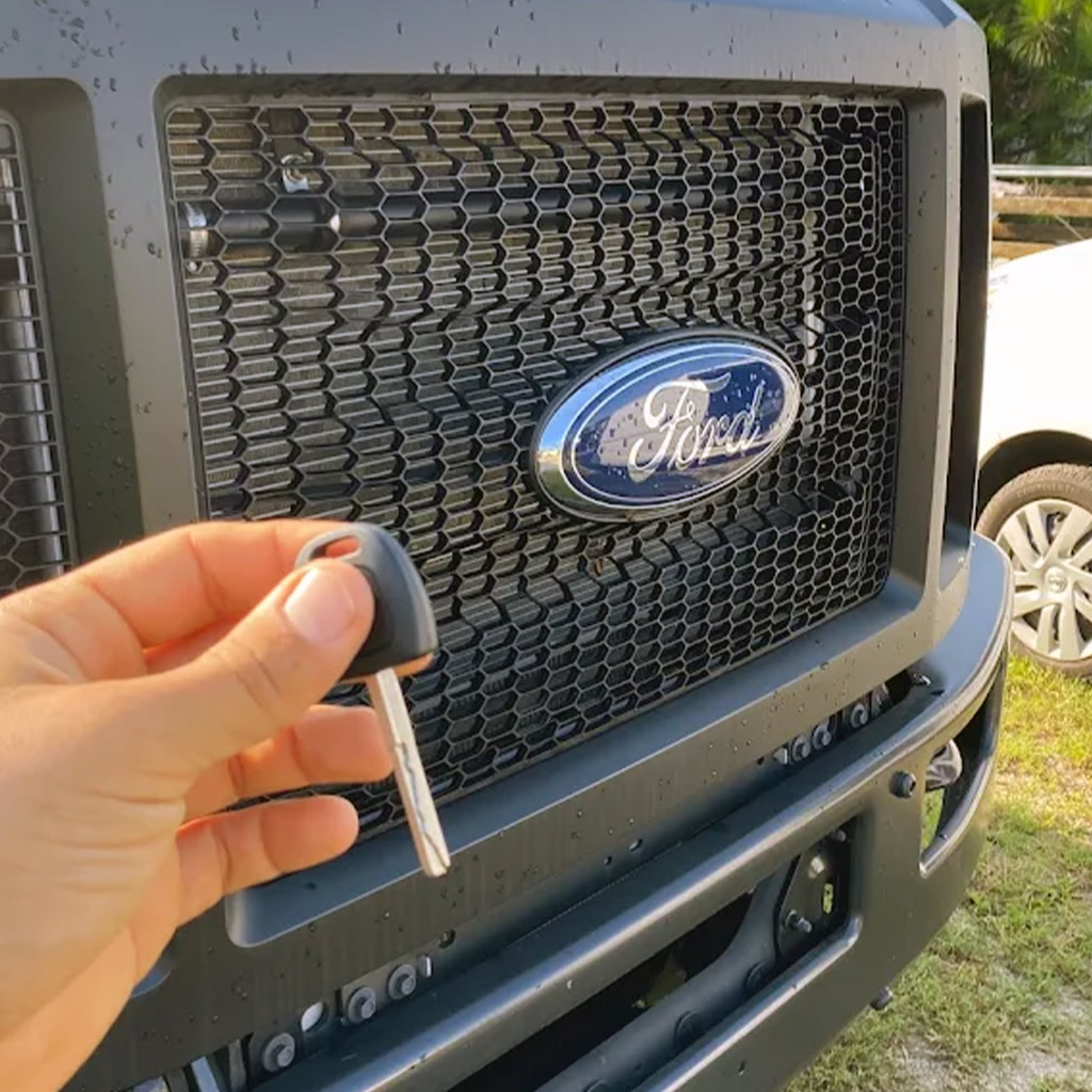 Ford car key held in front of vehicle grille – automotive locksmith service in Panama City Beach
